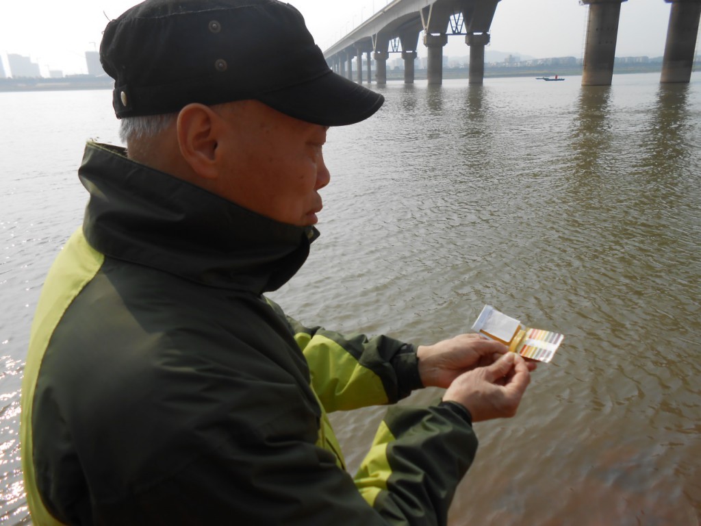 River monitor Yu Lixiang is testing the water quality of the Xiang River near Hunan’s provincial capital Changsha with a simple pH testing kit that is used by thousands of volunteers across China to identify pollution and pressure governments and businesses to clean up their act. 